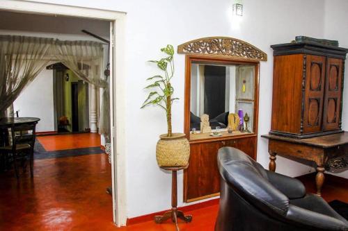 a living room with a potted plant and a mirror at Ankelipitiya in Kotadeniyawa