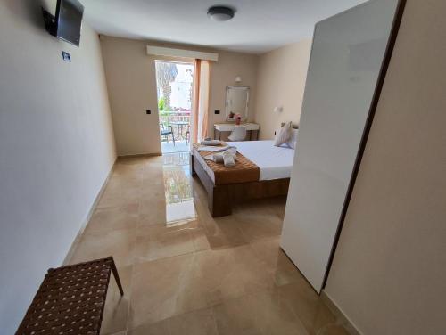 een slaapkamer met een bed en een deur naar een balkon bij YANNA Studios & Apartments in Tsilivi