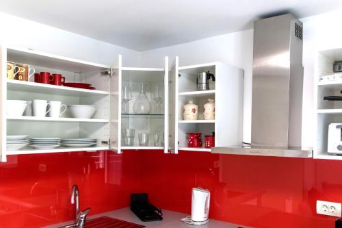 - une cuisine avec des placards rouges et blancs et un évier dans l'établissement Apartment Studio MY RESIDENCE in the city center, à Ljubljana