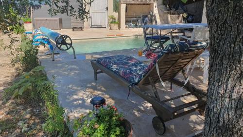- un lit et une table à côté de la piscine dans l'établissement L'Eterlou Saint Blaise, bel appartement neuf mansardé, à Saint-Blaise
