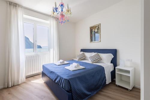 a bedroom with a blue bed and a chandelier at IseoLakeRental - Fantasy Lake in Castro