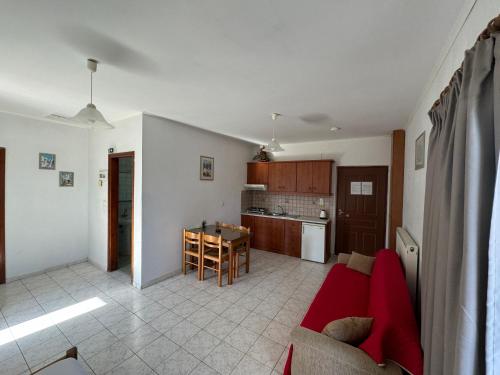 a living room with a red couch and a kitchen at Zac & Georgio Studios in Amoudara Herakliou