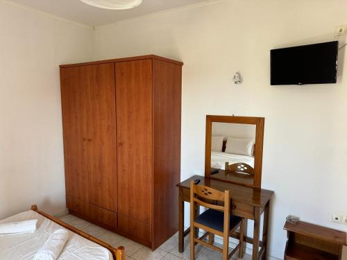 a bedroom with a wooden cabinet and a desk with a mirror at Zac & Georgio Studios in Amoudara Herakliou
