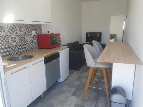 Il comprend une cuisine équipée d'un comptoir et d'un four micro-ondes. dans l'établissement Le cabanon du Caramus, à Frontignan