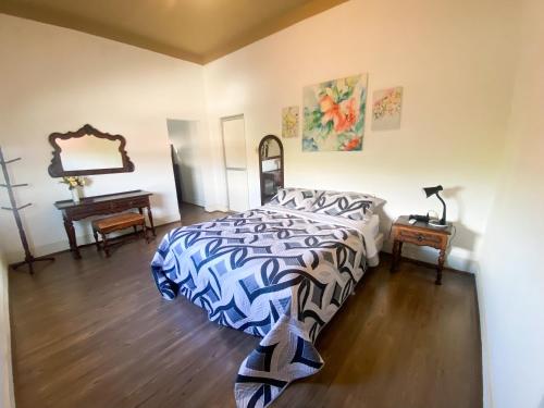 a bedroom with a bed and a table and a mirror at Casa Bizzacchi Pinhal in Espirito Santo Do Pinhal