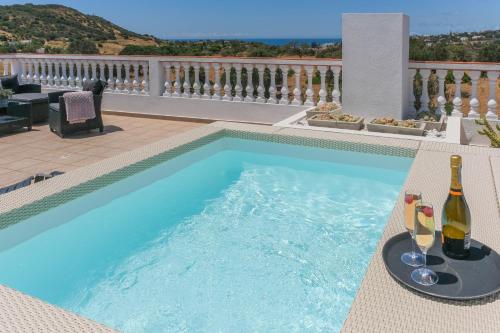 a swimming pool with wine bottles and glasses in it at Casa Luisandra Boutique Hotel B&B in Luz