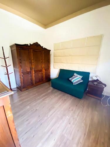 a living room with a blue couch and a wooden floor at Casa Bizzacchi Pinhal in Espirito Santo Do Pinhal