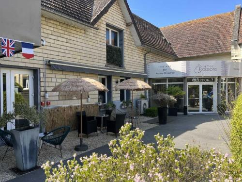 a group of chairs and umbrellas in front of a building at Hotel Best Western La Mare &Ocirc; Poissons in Ouistreham