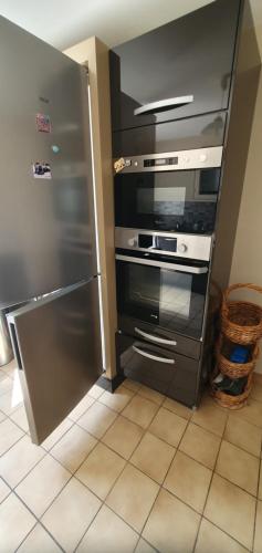 Il comprend une cuisine équipée d'une cuisinière en acier inoxydable et d'un réfrigérateur. dans l'établissement Maison Hortensias Fromentine 8 pers près de la plage, à La Barre-de-Monts