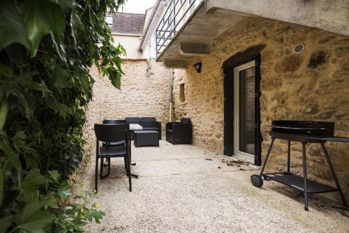 a patio with chairs and a table and a piano at Le Trèfle à Quatre Feuilles in Siorac-en-Périgord