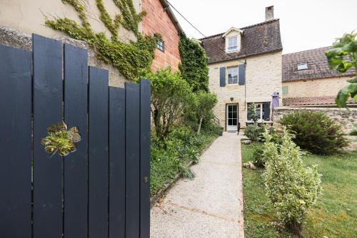 a gate in a yard with a driveway at Le Trèfle à Quatre Feuilles in Siorac-en-Périgord