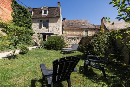 two black chairs sitting in the yard of a house at Le Trèfle à Quatre Feuilles in Siorac-en-Périgord
