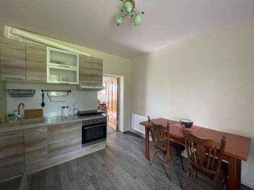 a kitchen with a wooden table and a dining room at Viesu nams Vijas in Degumuiža