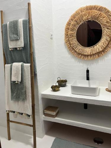 a bathroom with a sink and a mirror and towels at Casa do Pátio - Barragem do Alqueva in Granja