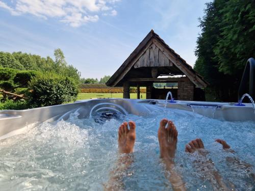 a person with their feet in a swimming pool at Harcówka in Miękisz Nowy