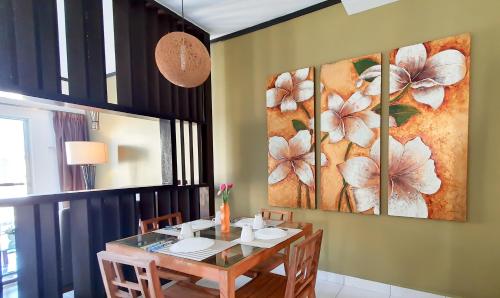 a dining room with a table and two paintings on the wall at Gold Coast Morib Apartment in Banting