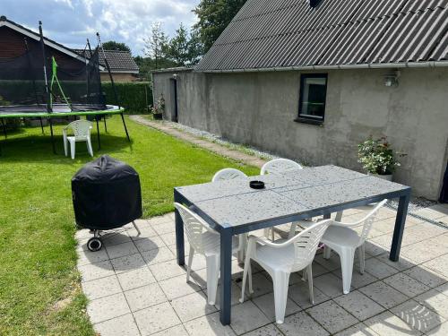 un tavolo e sedie e un tavolo da ping pong e una griglia di A cozy house to stay in Vandel a Vandel
