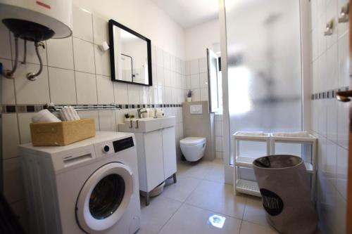 łazienka z pralką i toaletą w obiekcie Holiday Home Movica w mieście Mandre