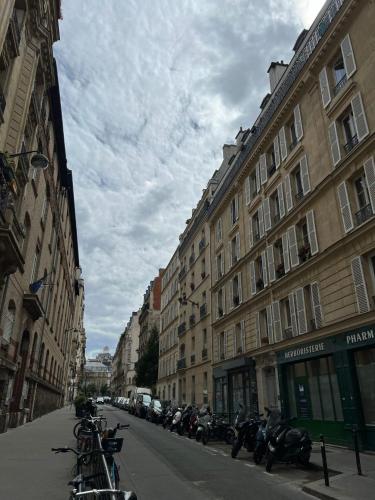 une rangée de motos garées dans une rue à côté des bâtiments dans l'établissement Le Havre Montmartrois, à Paris