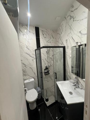 une salle de bain avec une douche, des toilettes et un lavabo dans l'établissement Le Havre Montmartrois, à Paris