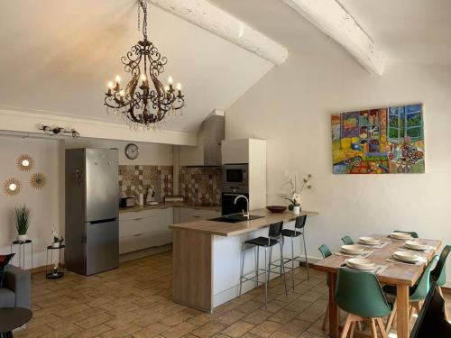 une cuisine et une salle à manger avec un lustre dans l'établissement Duplex familial au cœur de la cité médiévale, à Aigues-Mortes