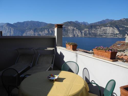 a table and chairs with a view of the water at Casa Cressotti appartamenti in Malcesine