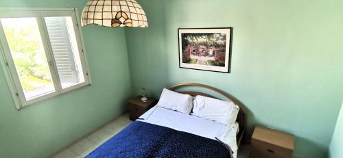a bedroom with a bed and a window at Villette di Torre Inserraglio in Nardò