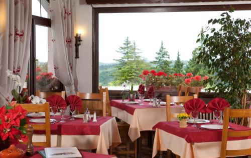 un comedor con mesas con manteles rojos en Logis Hôtel La Petite Chaumière en Gex