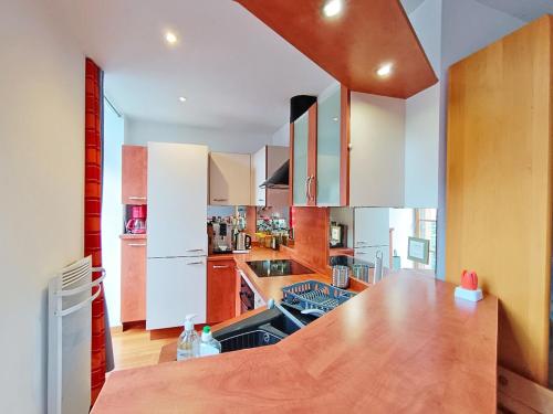 une cuisine avec des armoires blanches et un comptoir en bois dans l'établissement Le nid d'oeillet, T3 bis, wifi, jardin commun, à Luchon