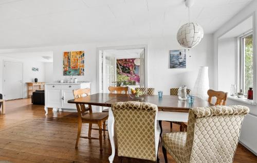 a kitchen and dining room with a wooden table and chairs at Three-Bedroom Apartment In Broager in Broager