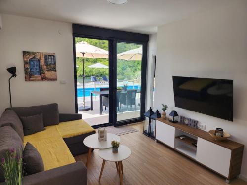 a living room with a couch and a flat screen tv at Villa Krivokapic in Trebinje