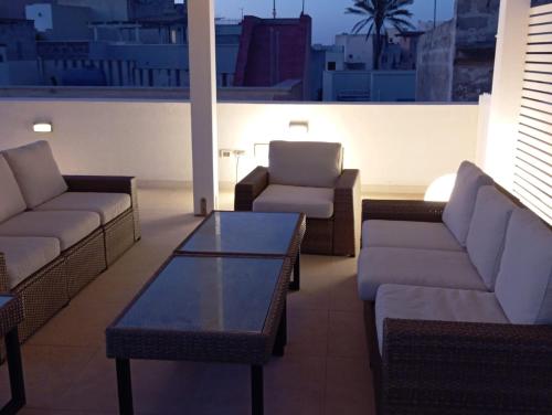 a rooftop patio with couches and a coffee table at Maruzza Home in Favignana