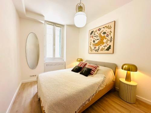 une chambre avec un lit et un miroir dans l'établissement Appart Suquet Cannes, à Cannes