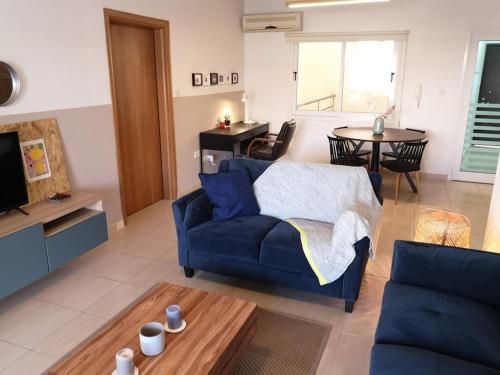 a living room with a blue couch and a table at Yippee! at Ermou Square Amazing Location View in Larnaca