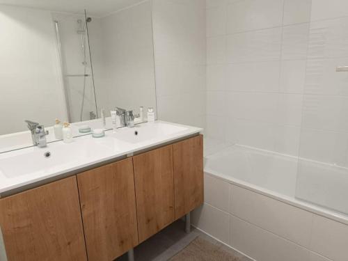 une salle de bain avec un lavabo, un miroir et une baignoire dans l'établissement T2 neuf avec terrasse proche Avignon, à Villeneuve-lès-Avignon