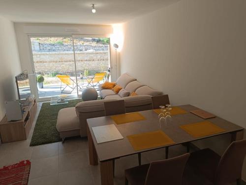 un salon avec un canapé et une table dans l'établissement T2 neuf avec terrasse proche Avignon, à Villeneuve-lès-Avignon