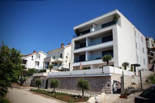 a white apartment building with trees in front of it at Savina Bliss Residences in Herceg-Novi