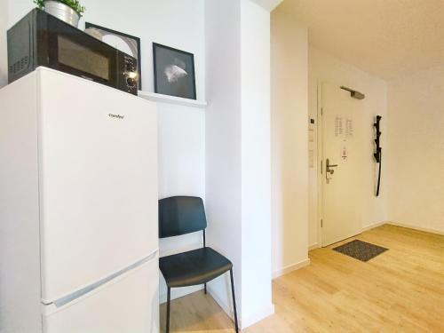 a room with a chair and a white wall at Bright Apartment für bis zu 5 Erlangen in Erlangen