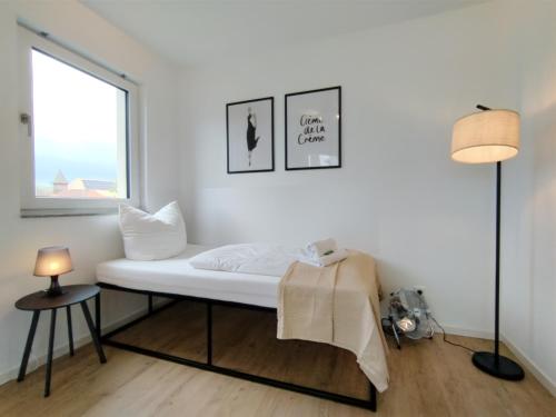 a bed in a white room with a window at Bright Apartment für bis zu 5 Erlangen in Erlangen