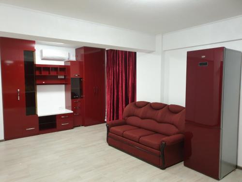 a living room with a red chair and a kitchen at Porto DelMar in Constanţa