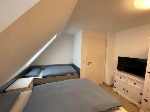 a attic bedroom with a bed and a television at Auszeit in Zeltingen-Rachtig