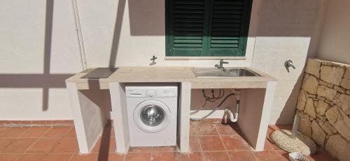 a washing machine under a counter with a sink at Villette di Torre Inserraglio in Nardò