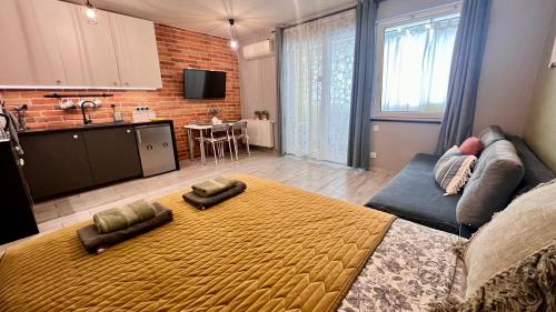 a living room with a couch and a kitchen at Roztocka studio, free parking, 1 tram to the city & PGE National Stadion, by Cosmo Spirit in Warsaw