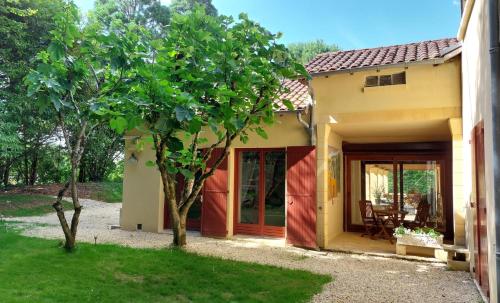 a small house with a tree in front of it at Les Eaux Vives in Manaurie