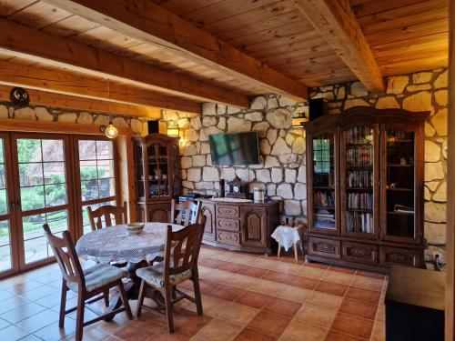a dining room with a table and a stone wall at Harcówka in Miękisz Nowy