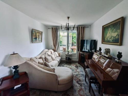 a living room with a couch and a tv at Charmante maison à Rueil-Malmaison in Rueil-Malmaison