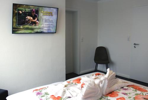 a bedroom with a bed with a tv on the wall at Haus Deutsche Bucht in Borkum