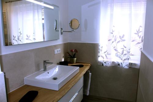 a bathroom with a sink and a mirror and a window at Haus Deutsche Bucht in Borkum