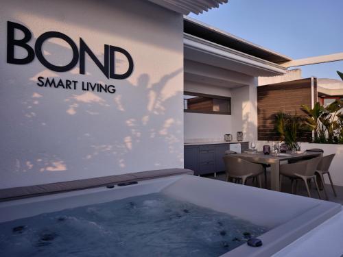 a jacuzzi tub in the backyard of a home at Bond Smart Living Suites in Athens