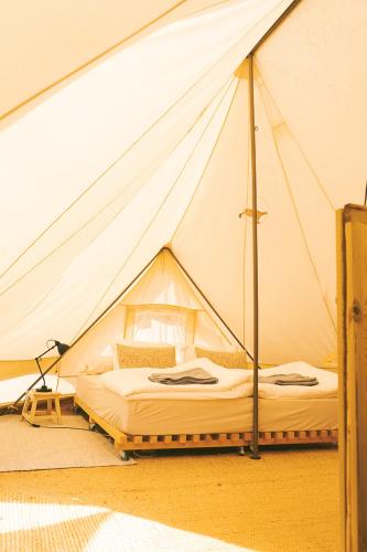 a bed in a tent in a room at Tente Glamping sans vis à vis, nature & calme, côte Vicentine in Rogil
